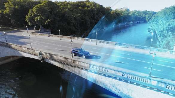 BMW Série 5 Berline G30 en mouvement dans une eDrive Zone BMW Série 5 Berline G30 restylage 2020 en Phytonicblau, vue de trois quarts avant, en mouvement dans une eDrive Zone sur un pont