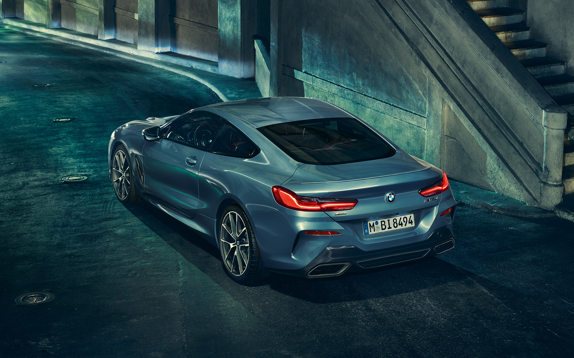 BMW Série 8 Coupé, vue à trois quarts de la poupe La BMW Série 8 Coupé photographiée de l'arrière, vue à trois quarts à gauche, à l'arrêt dans un décor urbain.