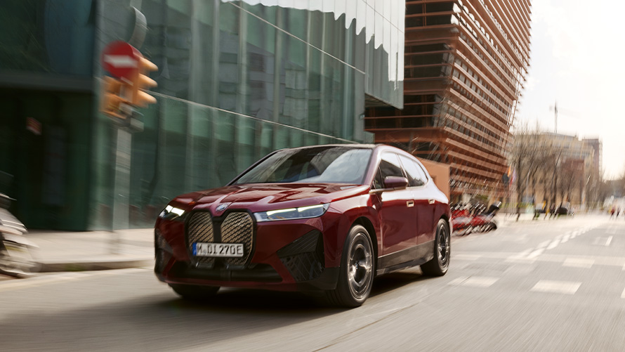 BMW iX i20 SUV électrique BMW iX xDrive50 assistance au conducteur BMW iX i20 2021 SUV électrique BMW iX xDrive50 Aventurinrot roulant dans un environnement urbain