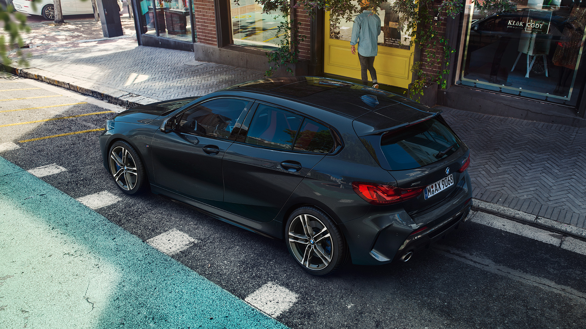 BMW M135i xDrive, en stationnement. BMW M135i xDrive en Saphirschwarz metallic, vue de trois quarts de profil en plongée, en stationnement.