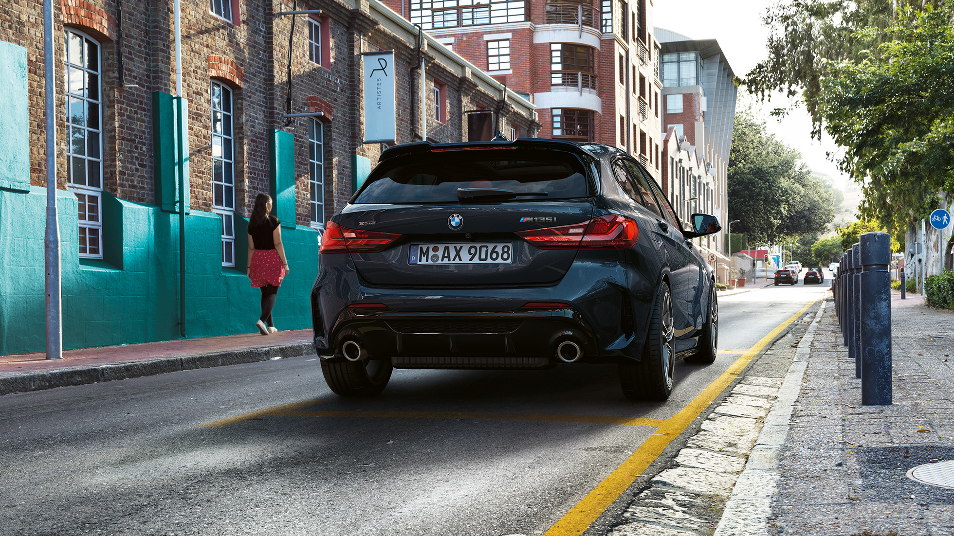 BMW M135i xDrive, vue de l’arrière. BMW M135i xDrive en Saphirschwarz metallic, vue de l’arrière, en stationnement.