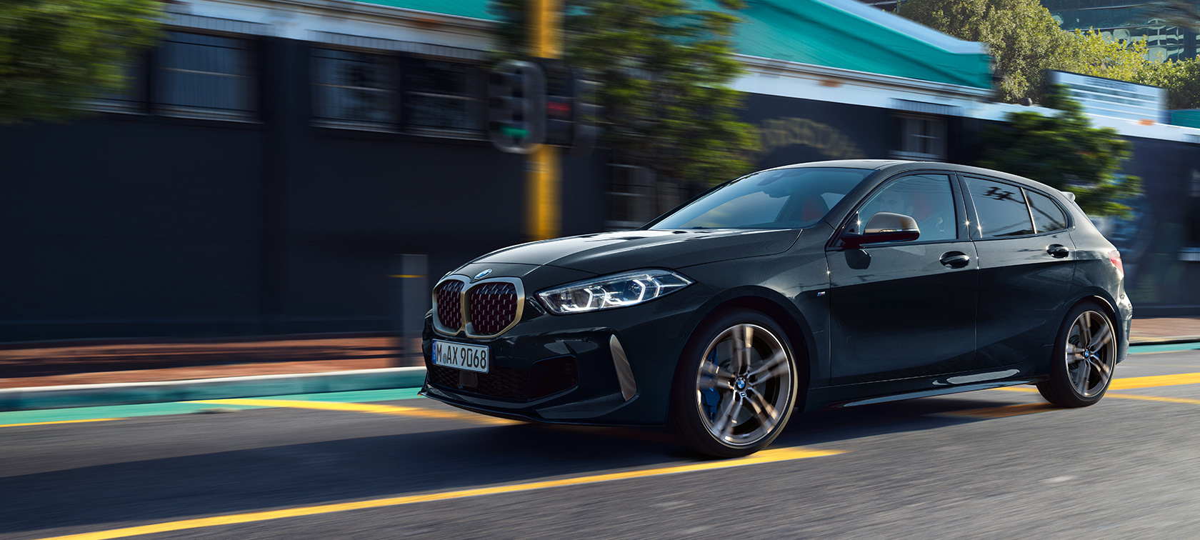 La nouvelle BMW M135i xDrive en Saphirschwarz metallic, vue de trois quarts de profil, en marche.