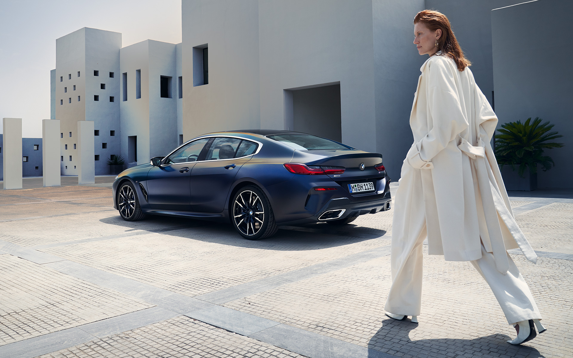 BMW M850i xDrive Gran Coupé G16 LCI restylage 2022 BMW Individual Frozen Tansanitblau metallic vue de trois quarts arrière avec modèle féminin