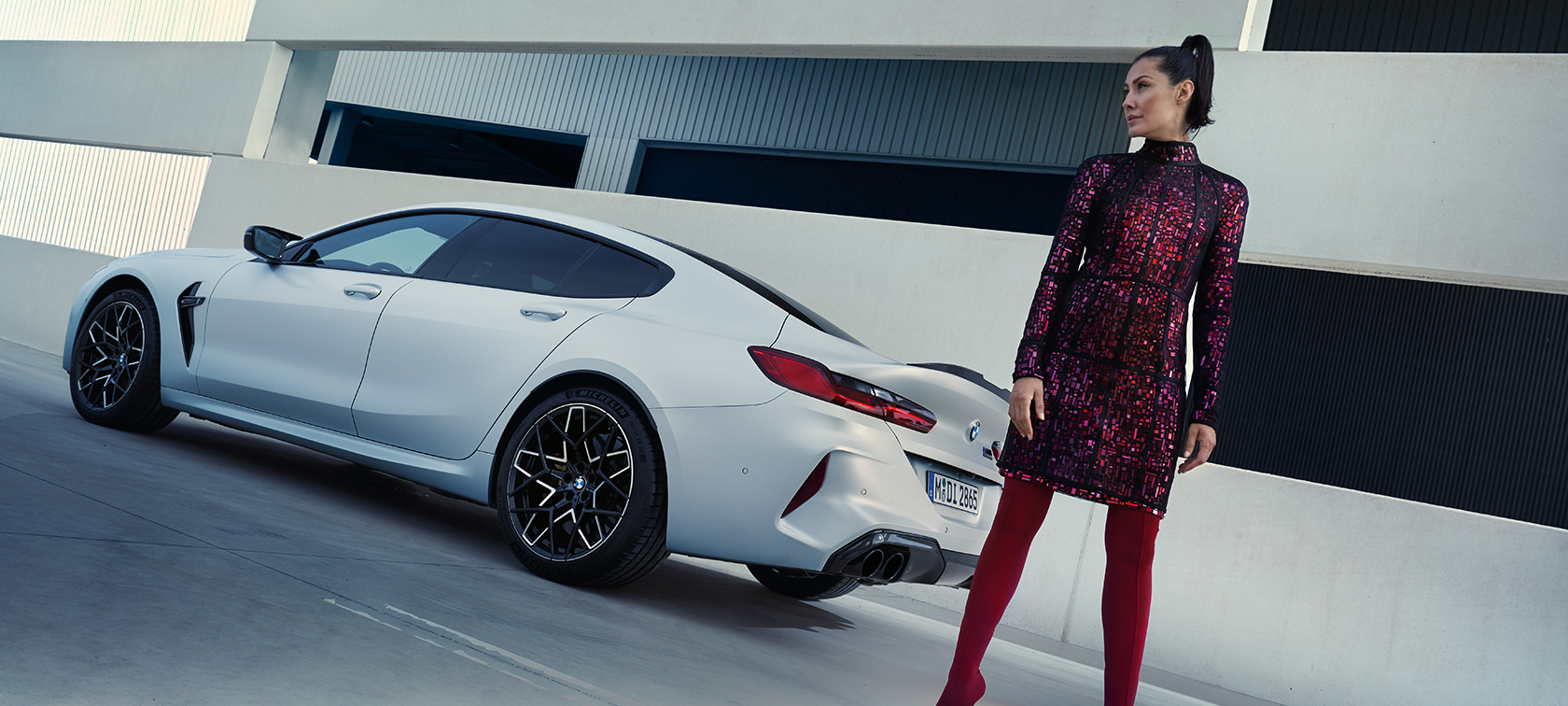 BMW M8 Competition Gran Coupé F93 LCI restylage 2022 BMW Individual Frozen Brilliant White metallic vue de trois quarts arrière avec modèle féminin à côté du véhicule