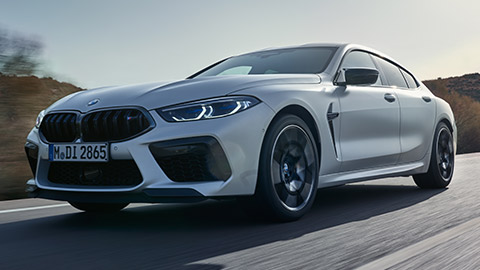 BMW M8 Gran Coupé (F93) vue de trois quarts de profil à l’arrêt avec modèle BMW M8 Gran Coupé (F93) vue de trois quarts de profil à l’arrêt avec modèle