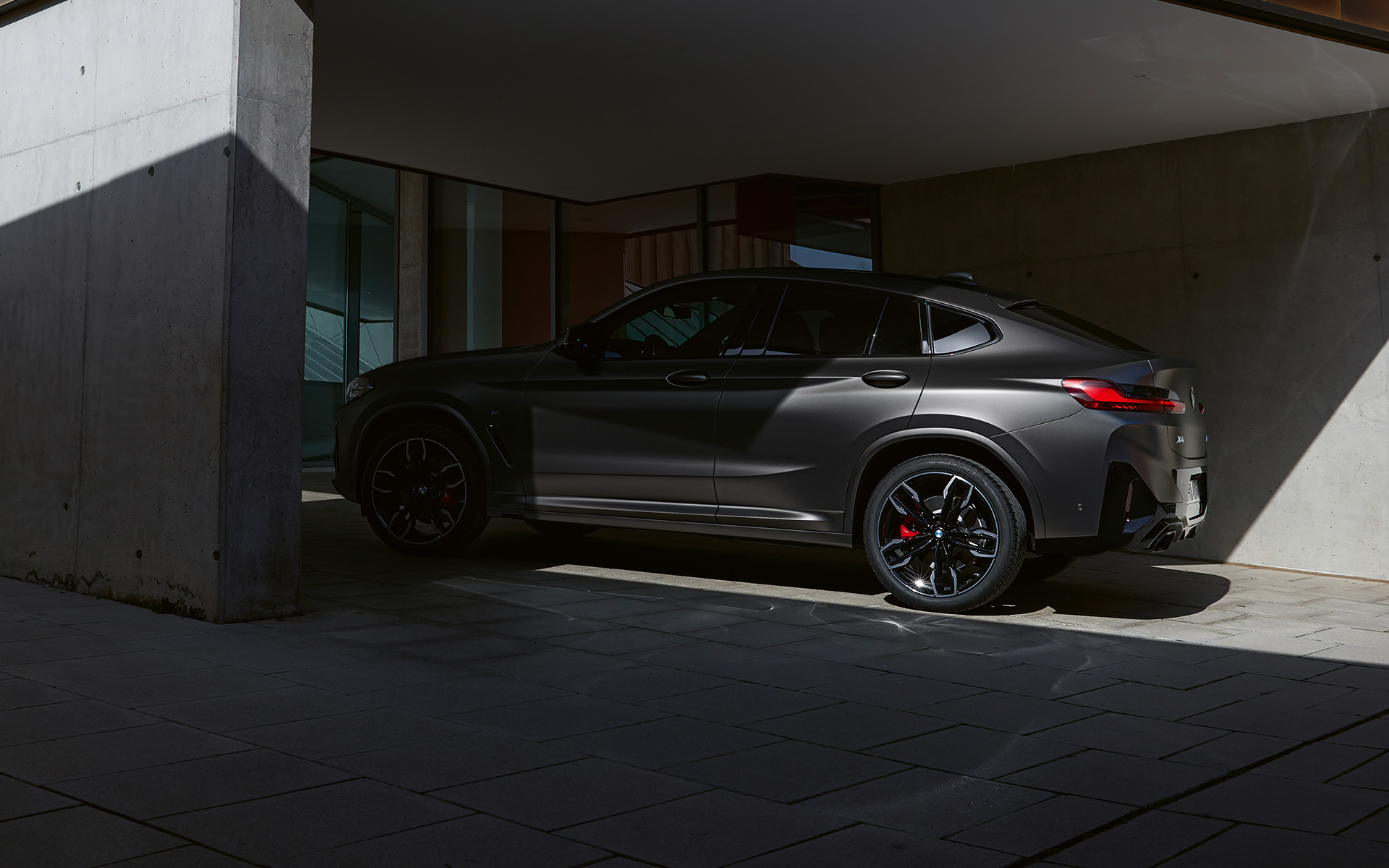 BMW X4 M40i G02 LCI 2021 Facelift vue de profil à moitié à l'ombre devant une entrée de maison