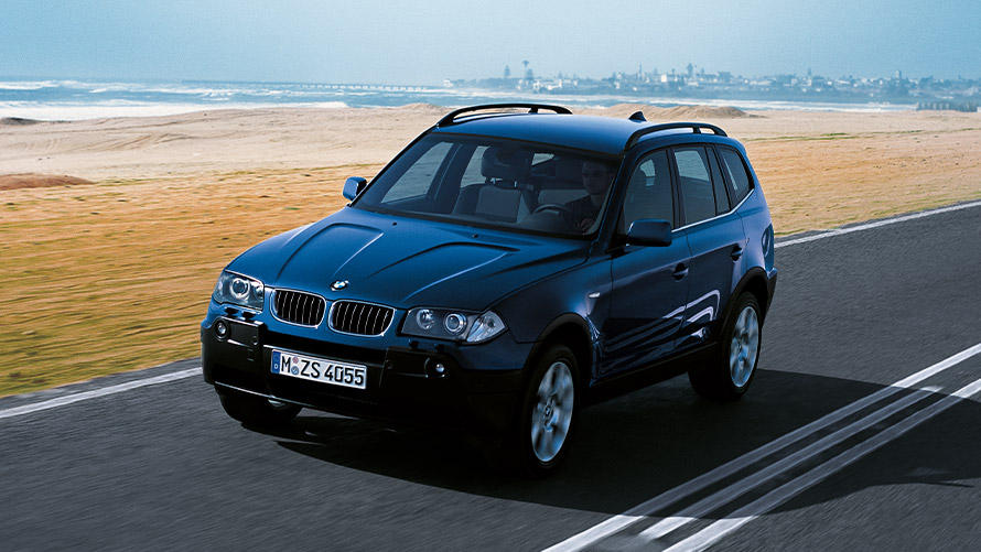 BMW X3 E83 de première génération, vue de trois quarts avant en mouvement sur la route Modèles BMW X BMW X3 E83 de première génération, vue de trois quarts avant en mouvement sur la route