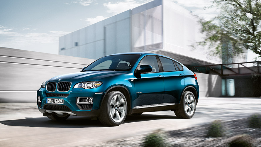 BMW X6 E71 de première génération, vue de trois quarts de profil devant un bâtiment Modèles BMW X BMW X6 E71 de première génération, vue de trois quarts de profil devant un bâtiment