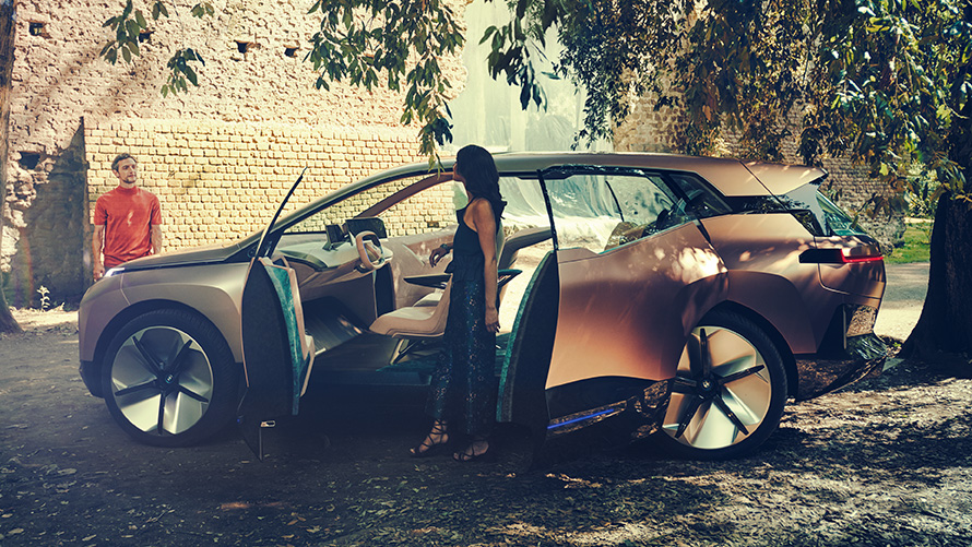 Flanc de la BMW Vision iNEXT Flanc de la BMW Vision iNEXT, femme près de la porte ouverte et homme à l'arrière-plan