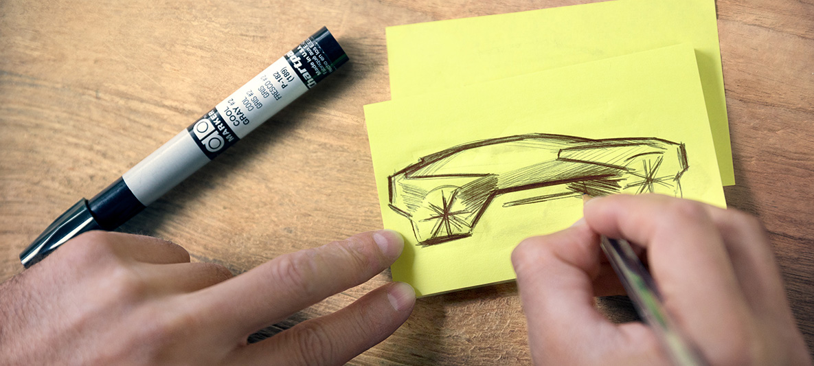 Esquisse de la BMW Vision iNEXT Des mains dessinent une esquisse de la BMW Vision iNEXT sur un post-it