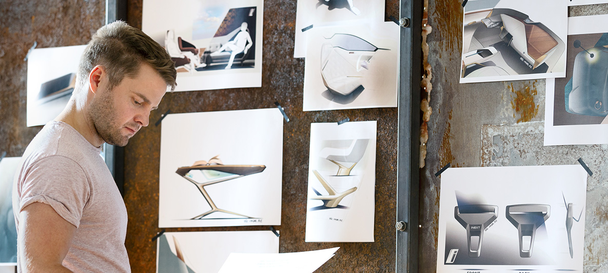Esquisses de la BMW Vision iNEXT Homme devant un mur avec des esquisses de la BMW Vision iNEXT