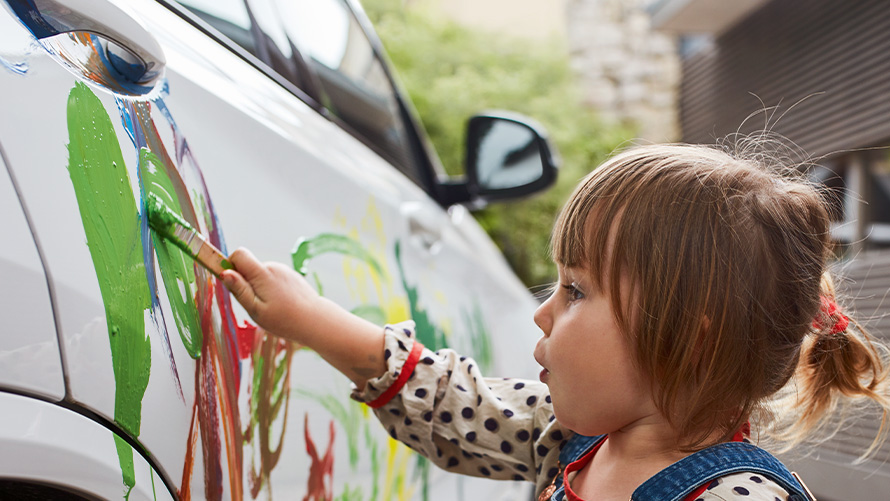 Réparations et soins Enfant peint une BMW en couleur avec son pinceau