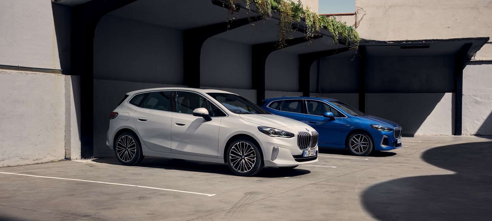 BMW Série 2 Active Tourer 230e Hybride Rechargeable U06 2021 M Portimao Blau métallisé à la borne de recharge - vue de trois quart face